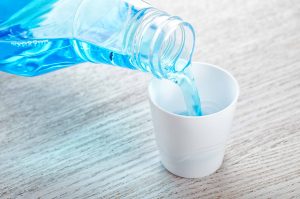 Manahawkin dentist , Blue mouthwash being poured into cap of bottle